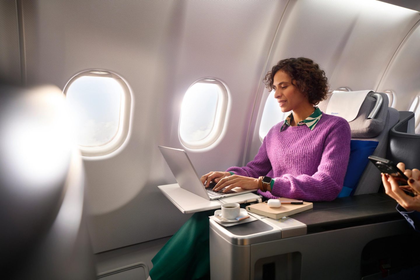 Discover FlyNet Eine Frau in der Business Class schaut auf ihren Laptop