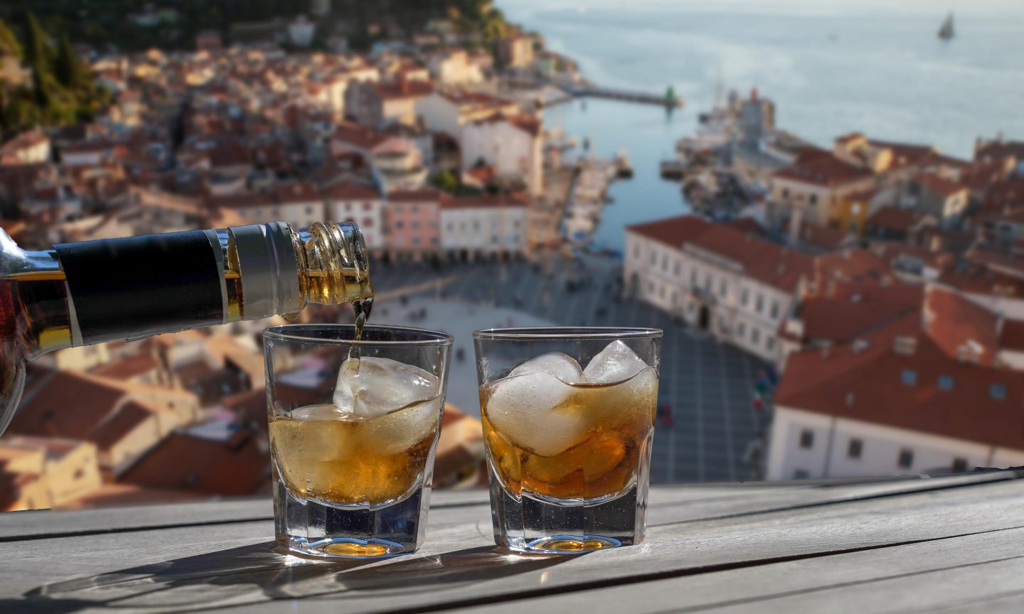 Two rakija schnapps with Dubrovnik in the background Two rakija schnapps with Dubrovnik in the background