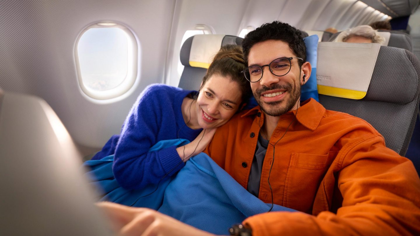 Entertainment auf der Langstrecke Ein Paar sitzt in der Economy Class und schaut sich das Entertainment-Programm an
