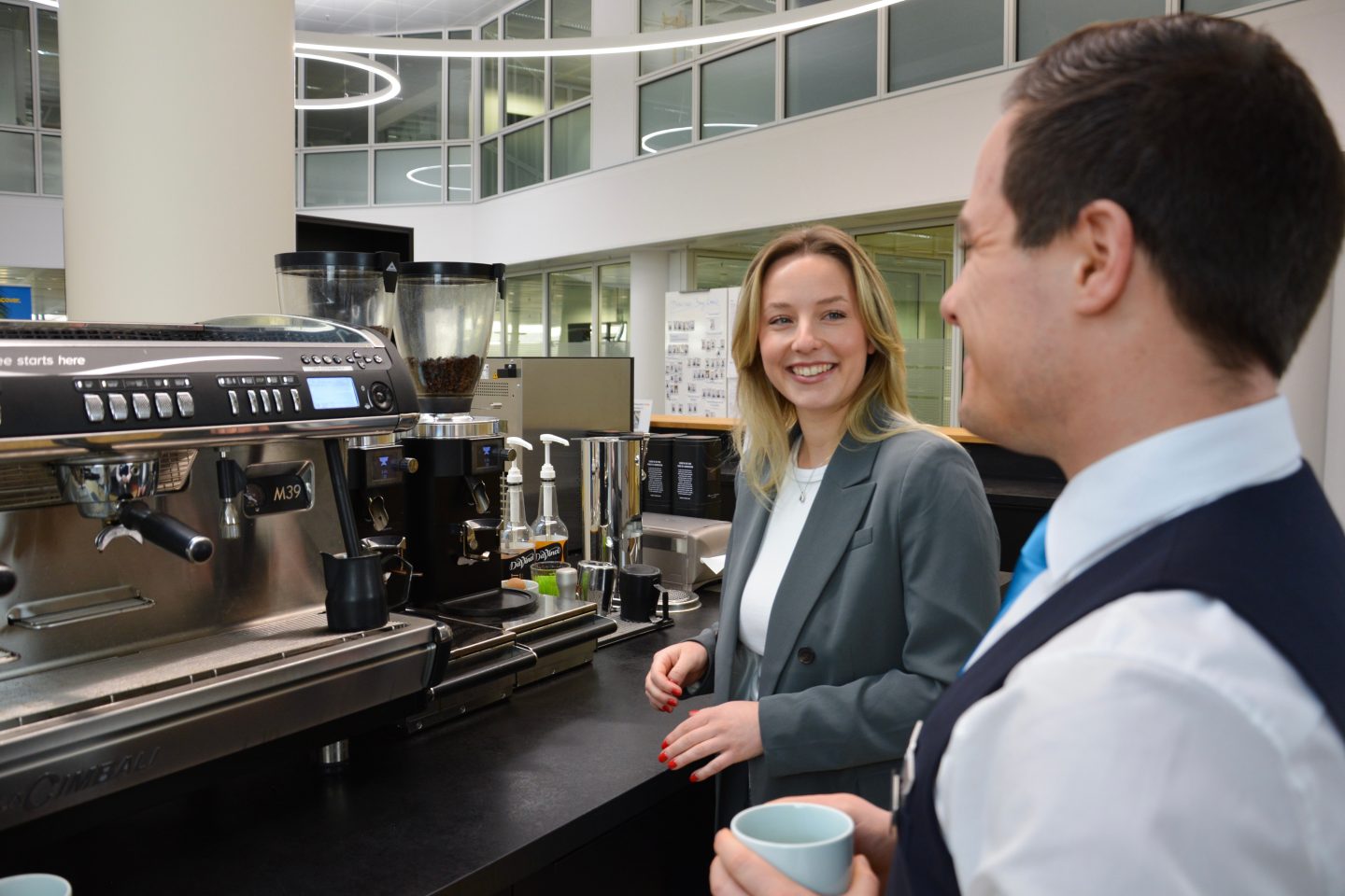 Two Discover Airlines employees at the coffee machine in the bay