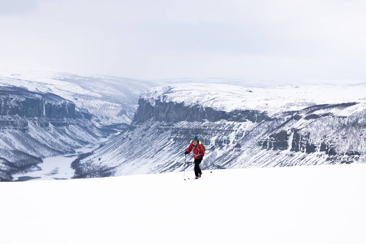 Frau auf Skiern in den schneebedeckten Bergen