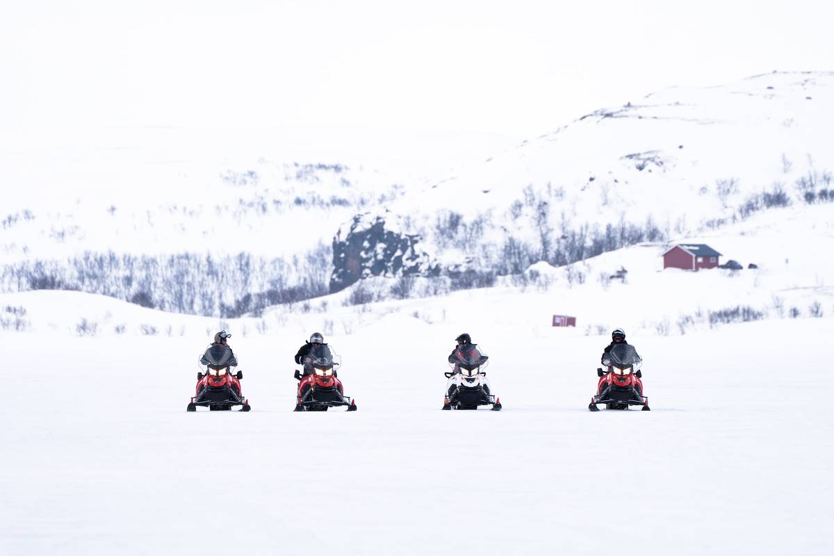 Four people on snowmobiles