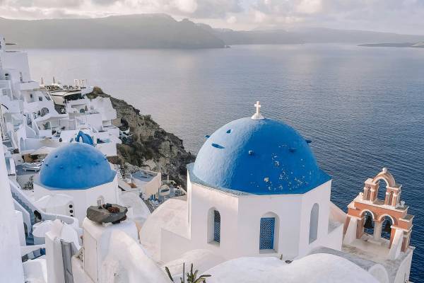 Blue roofs and white houses in front of the sea of Santorini